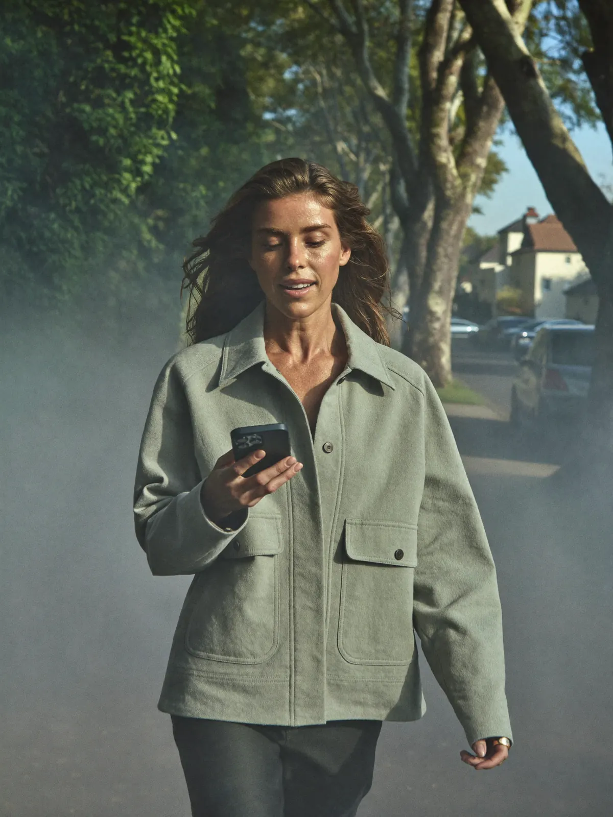 A woman on a morning walk, looking at her phone